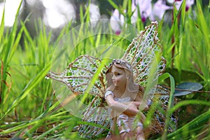 image of magical little fairy sitting in the forest.