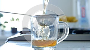 Image with Making a Hot and Aromatic Tea Using a Strainer and Natural Tea Leafs photo