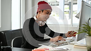 Image of male creative graphic designer is using color selection and working on computer at workplace .