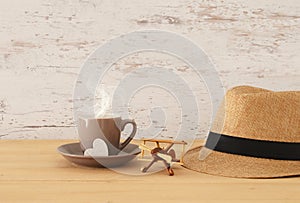 Image of male fedora hat, cup of hot coffee or tea and plane toy