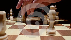 Image of male hand holding chess figure