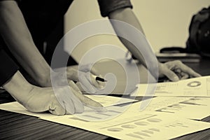 Image of male hand pointing at business document.