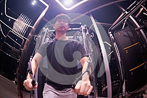 The image of the man in the gym in the dark With a perfect body, high cross workout. Concept of healthy male with exercise.