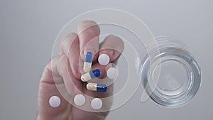 Image with Man Hands Taking Some Medicine Pills From Table Glass Surface