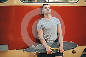 Image of a man with longboard going on road