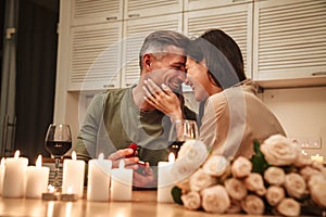 Image of man making proposal to his girlfriend during romantic dinner