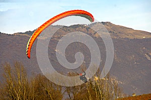 Image of man practicing parachuting over mountain landscape