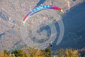 Image of man practicing parachuting over mountain landscape