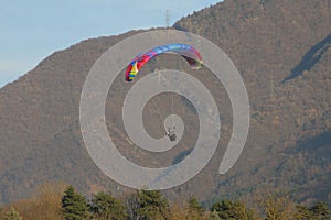 Image of man practicing parachuting over mountain landscape