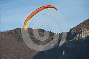 Image of man practicing parachuting over mountain landscape