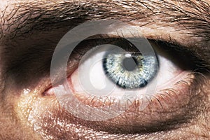 Image of man`s blue eye close up.