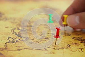 Image man& x27;s hand attached pins to a map, showing location or travel destination. selective focus.