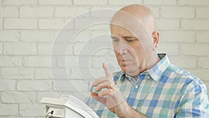 Image with a Man Thinking and Gesticulating Before Dialing a Phone Number