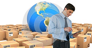 Image of man using tablet with stacks of boxes and globe on white background