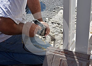 Image of man worker holding ceramic tile drill machine while drilling old tiles