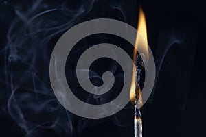 An image of a match stick flame in front of a black