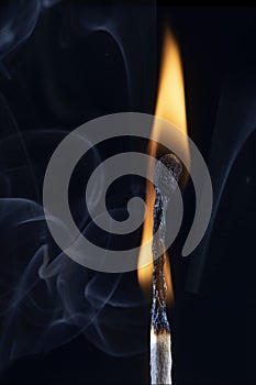 An image of a match stick flame in front of a black