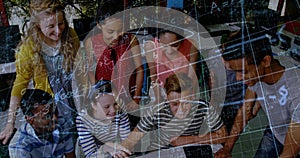 Image of math formulas moving over happy diverse pupils working on laptop