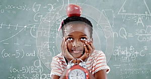 Image of math formulas over thoughtful african americna girl with apple over blackboard photo