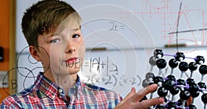 Image of mathematical formulae over smiling schoolboy