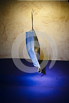 image of medical mask hooked on a fishing hook with selective lighting