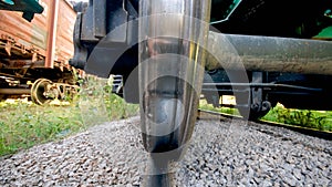 Photo between the metal rail and train wheel on railroad