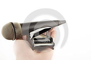 Image of miniature piano microphone hand white background