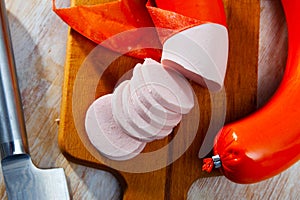 Mortadela sausage cut in slices on a wooden surface photo