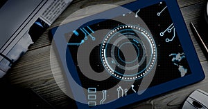 Image of motherboard and circular scanner processing data on screen of tablet on desk