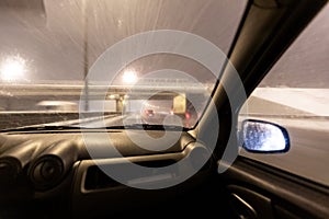 Image with motion blurred effect.Cars fast drive on the winter speedway or highway with roadway lighting in a snow storm