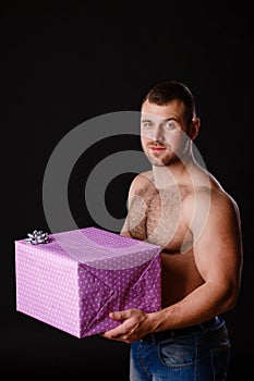 Image of muscular man holding xmas gifts, isolated on black