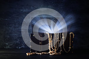 Image of mysterious opened old wooden treasure chest with light. An adventure and fantasy medieval period. Selective focus.