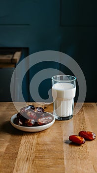 Image Neat arrangement of dates next to a glass of milk on the kitchen table