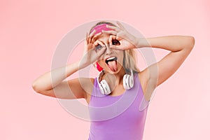 Image of nice amusing woman grimacing with headphones over neck