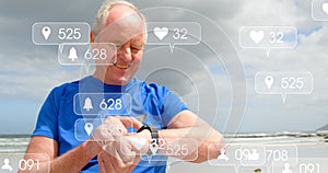 Image of notification bars over senior caucasian man using smartwatch at beach photo