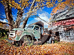 Image of an old abandoned truck and a barn