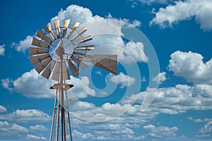 Image of old metal Wind mill against a blue sky