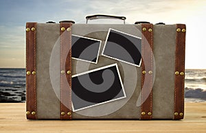 Image of old vintage luggage with blank photos for photography montage mockup over sea tropical landscape.