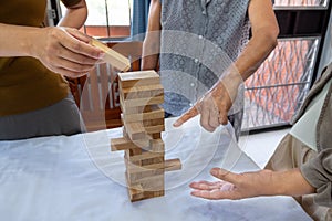 Image of old woman and two girls hand holding blocks wood game to growing up of home business, Risk of management and strategy