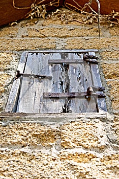 A wooden window cover on an old brick building on grounds of the Gonzalez Alvarez House in Historic St. Augustine, Florida photo