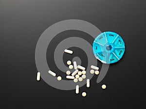 open pillbox with some pills