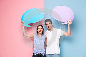 Image of optimistic couple holding copyspace commercial bubbles