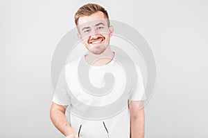 Image of optimistic positive young unshaved man in hat isolated over white wall background