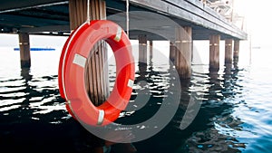 Image of orange life buoy on wooden pier at beach