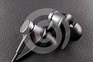 The image of a pair of earbuds on a black background, representing the integration of modern technology in youth culture