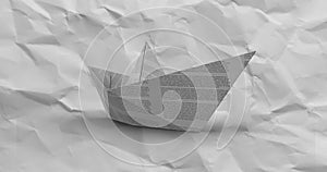 Image of paper boat over moving scrunched white paper texture background