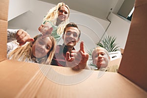 Image of parents and children looking inside cardboard box