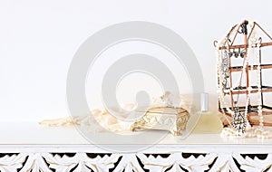 Image of pearls and perfume over white vintage wooden table. For mockup, can be used for photography montage