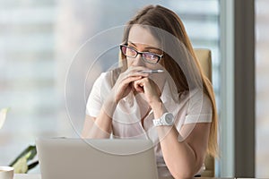 Image of pensive businesswoman seating in office