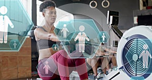 Image of people icons over diverse group training on rowing machines at gym